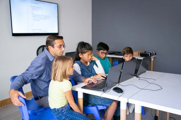 multiethnic-pupils-doing-task-with-help-teacher_74855-10288