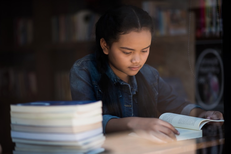 young-woman-reading-book-sitting-indoor-urban-cafe_1150-3950
